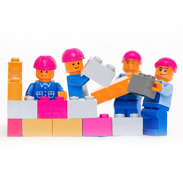 Lego men building a brick wall